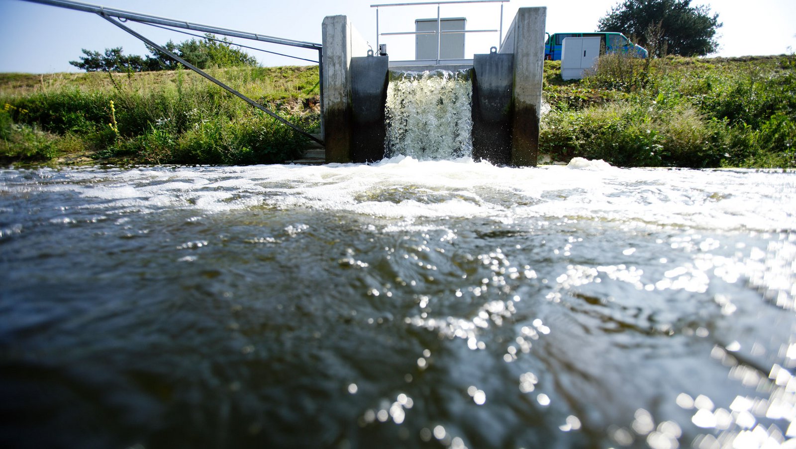 Kreislaufwirtschaft für effiziente Ressourcennutzung Blick auf ein Versickerungsbecken im Wasserwerk und den Wasserauslauf, aus dem Wasser auf das Feld läuft