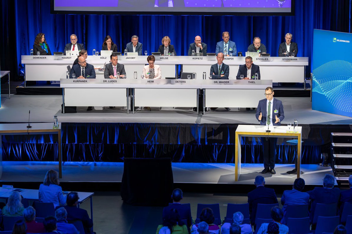 Vorstandsvorsitzender Henning R. Deters bei seiner Rede, im Hintergrund der Aufsichtsrat.